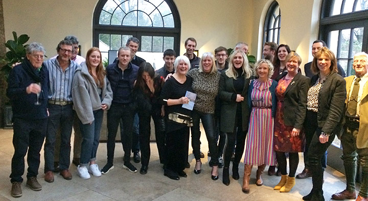 Jeffrey's wife Prue (holding the book) with family & friends